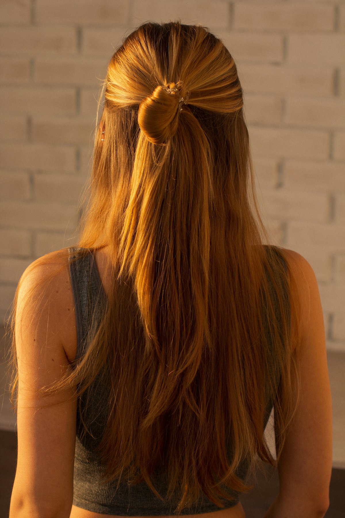 ツヤのある、まっすぐなロングヘアのハーフアップの後ろ姿
